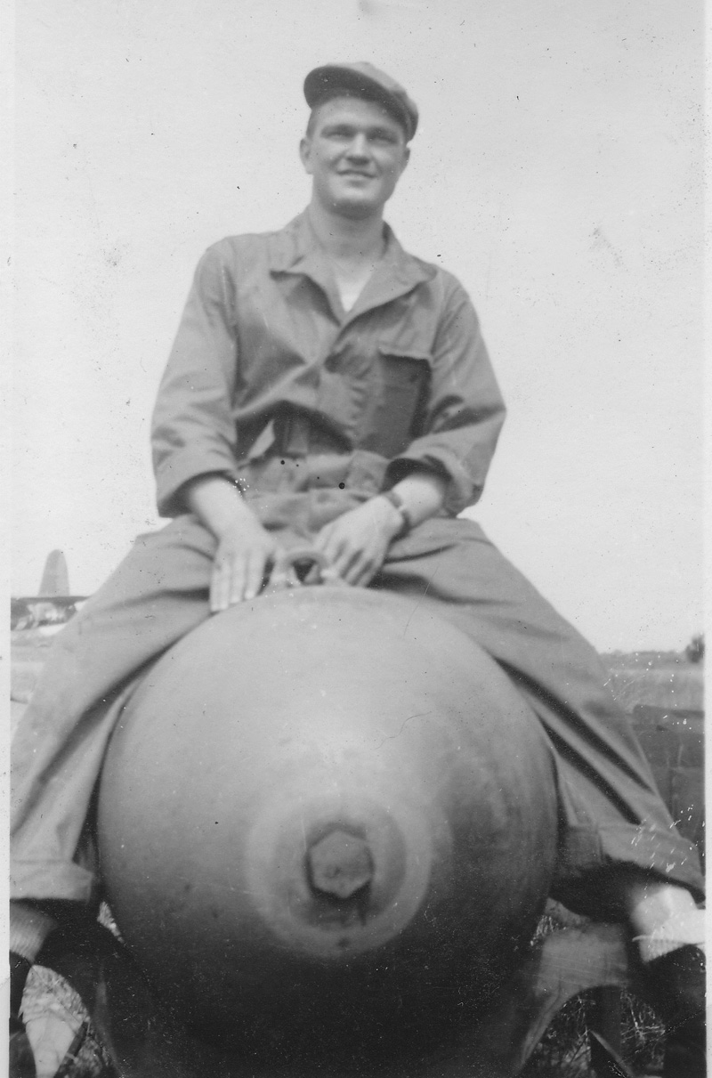 American B26 Marauder crewman sitting on 2000 pound bomb.