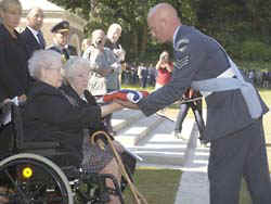 Sergeant Chris Mears from the Queens Colour Squadron, Royal Air Force Regiment presents the flag from Sgt Carmichaels coffin to his Next of Kin, Bunty McQuade