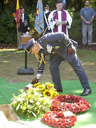 Air Chief Marshal Sir Peter Squire, the recentley retired Chief of the Air Staff, reads messages on the wreaths laid for Sgt Carmichael