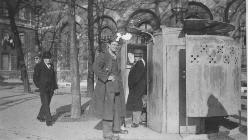 A smiling soldier walking pasted two ordinary Parisians to use a public toilet. Paris, France