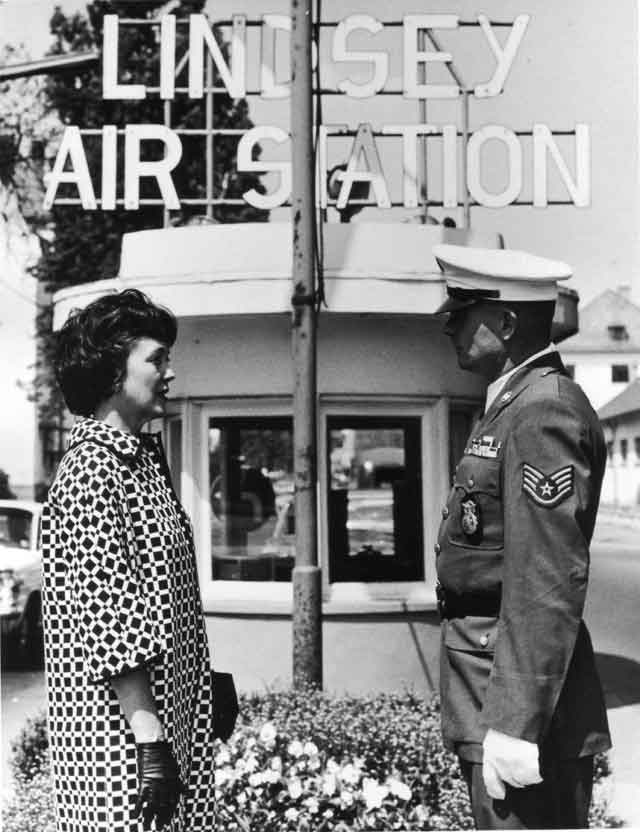 Lindsey 5: Lindsey's widow Evalyn at the entrance to Lindsey Air Station, Wiesbaden, Germany. The station was named for Darrell R. Lindsey and has since been closed.